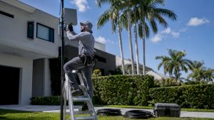 Technician adjusting outdoor cell booster antenna in backyard