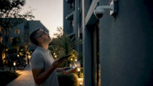 Property manager inspecting security camera outdoors