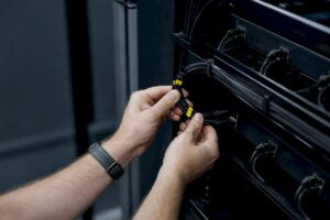 Hands installing redundant network cables