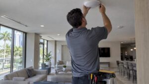 Installer mounting an access point in a condo lounge